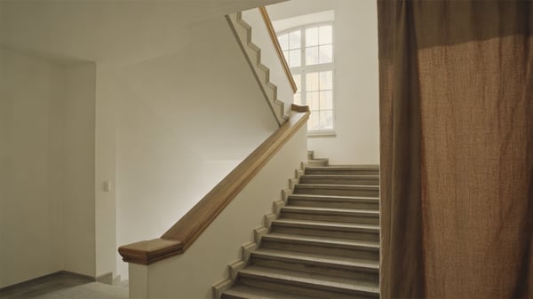 Gepflegtes Treppenhaus eines Mehrfamilienhauses mit Holzhandlauf