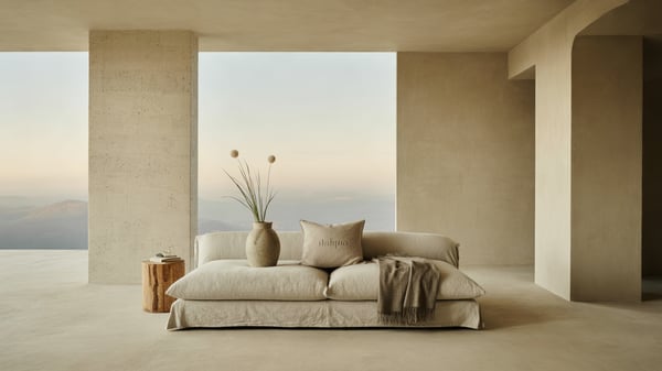 Gestalteter heller Wohnraum mit Leinensofa und Keramikvase